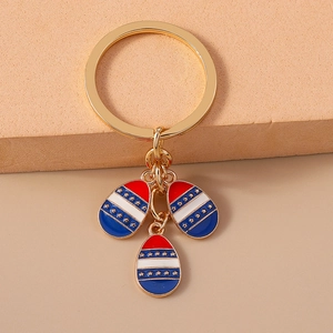 Detailed close-up of golden metal keychain featuring red, white, and blue enamel star charms