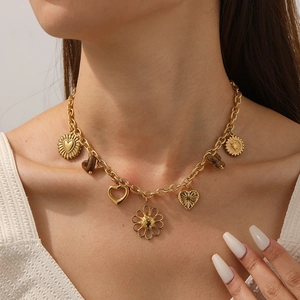 Golden stainless steel necklace with heart and sunflower pendants worn by a model