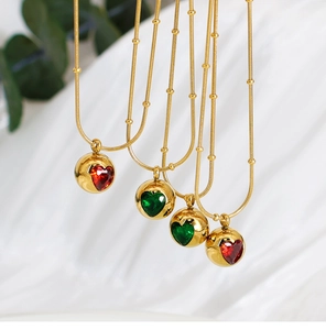 Détail de chaînes serpent dorées avec billes et pendentifs en zircon en forme de cœur