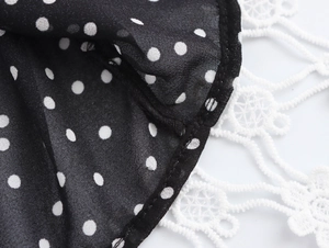 Detail of black polka dot fabric joined with delicate white lace trim on dress