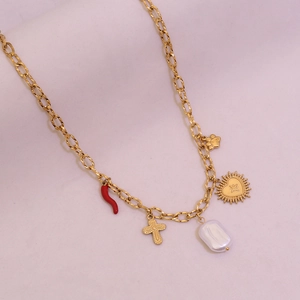 Détail du collier doré avec pendentifs piment rouge, croix, perle et cœur à rayons de soleil