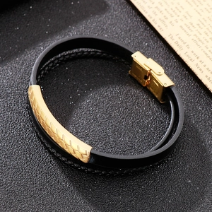 Macro detail of men's double-layer black leather bracelet with golden fish-scale metal clasp
