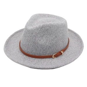 Detail of grey felt Fedora hat featuring a brown leather band and gold metal buckle