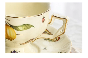 Macro detail of French vintage ceramic tea cup handle with lemon pattern and gold rim