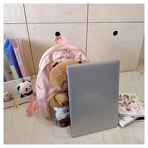 Pink student backpack with clear pocket showing large capacity next to a laptop