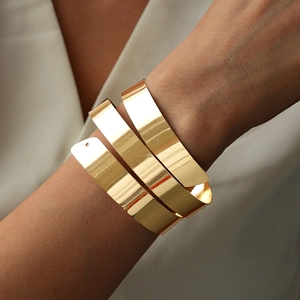 Close-up of a three-layered spiral golden arm cuff with high-polished metallic finish