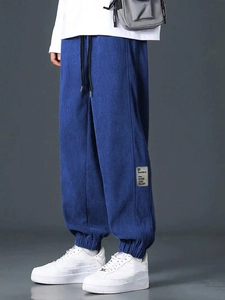 Detail of blue corduroy joggers featuring high texture fabric and graphic patch design