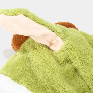 Detailed macro view of plush green dinosaur hat fabric with soft pom-pom textures