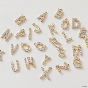 Detail view of 26 gold-plated 14K copper alphabet pendants with micro-pave cubic zirconia