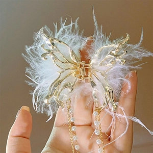 Detail of butterfly hair claw with white feathers and long pearl tassels
