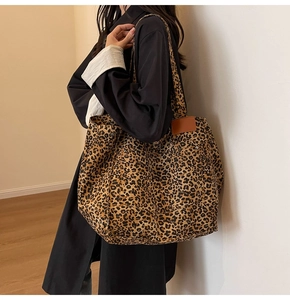 Detailed side view of large leopard print canvas tote bag styled with casual outfit