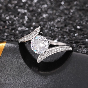 Macro shot of silver ring with large round main stone and side pavé diamonds detail