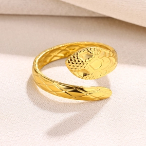 Macro shot of gold snake ring showing realistic scale texture and mesh pattern