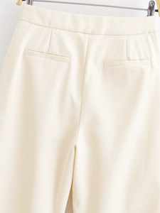 Close-up of the back waist details and decorative pockets on beige high-waist trousers