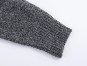 Detailed close-up of dark grey knit cuff with metallic lurex thread and ribbed texture