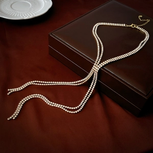 Detailed view of luxury gold double-layer tassel necklace with sparkling rhinestones