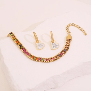 Macro detail of rainbow crystal bracelet and heart earrings on white stone