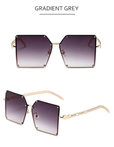 Detail of gradient grey lenses and golden chain temple on oversized square sunglasses