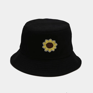 Dettaglio del ricamo a girasole su un cappello alla pescatora pieghevole in cotone nero