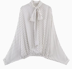 Close-up of white polka dot blouse with elegant bow tie neck and loose batwing sleeves