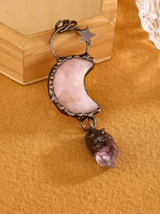 Detail of rose quartz moon and purple crystal pendant set in bronze star frame