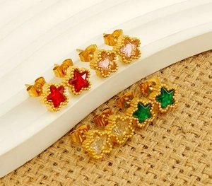 Detail of star-shaped zircon stud earrings in red, pink, green, and white with gold finish