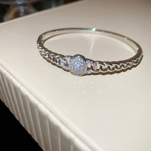 Vue macro d'un bracelet à maillons argentés avec un élément central en zircons scintillants