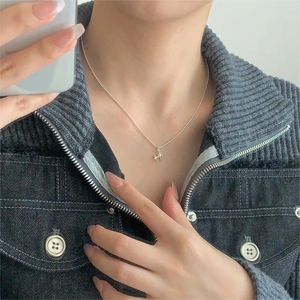 Detail shot of a minimalist 925 sterling silver star pendant necklace on a model