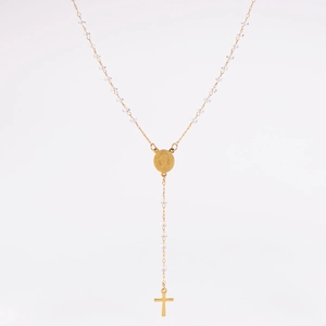 Gros plan du collier en acier inoxydable doré avec perles facettées et pendentif croix