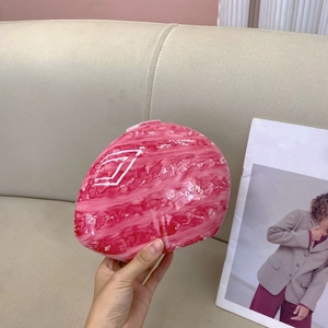 Detailed view of pink marble pattern clutch bag with glossy finish held in hand