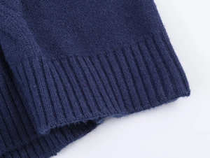 Close-up of navy blue polo knitwear showing ribbed cuffs and soft texture