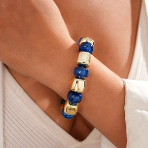 Close-up of geometric beaded bracelet with blue glitter resin and gold metal accents