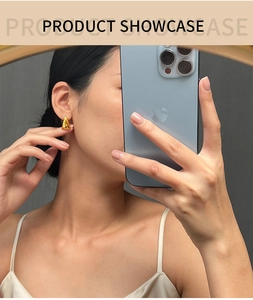 Polished gold triangle geometric earrings shown worn in a lifestyle mirror selfie