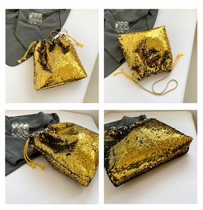 Detail view of a gold sequin bucket bag with a gold chain strap and yellow drawstrings