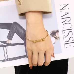 Minimalist gold adjustable steel ball bracelet featuring a knot design on female model