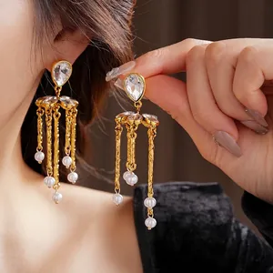 Vintage gold tassel earrings with teardrop crystals and white pearls shown on model