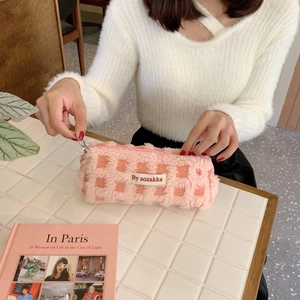 Detailed view of plush waffle fleece pencil case on tiled table with artistic book