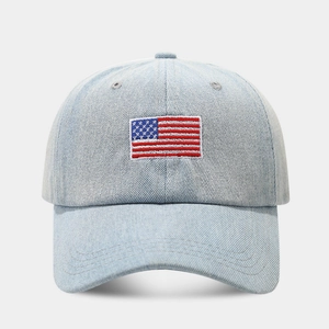 Close-up of the detailed American flag embroidery on light blue denim baseball cap