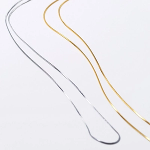 Collane minimaliste a catena serpente in oro e argento per donna su sfondo bianco