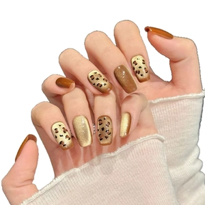 Faux ongles courts avec motif léopard et effet œil de chat doré étincelant chic