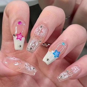 Detailed view of pink and blue gradient press-on nails with stars and rhinestones