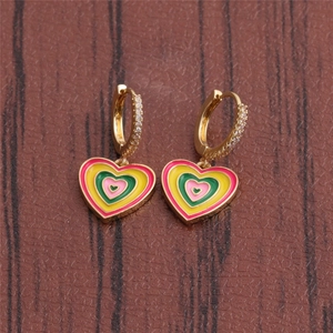 Detailed close-up of golden hoop earrings featuring colorful enamel heart charms and crystals