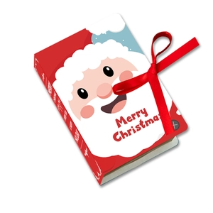 Detail of Christmas book-shaped gift box with Santa illustration and red silk ribbon