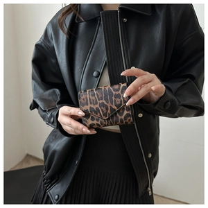 Dettaglio di un portacarte leopardato con design a busta e chiusura con bottone a scatto