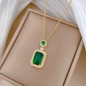 Macro detail of emerald cut green gemstone pendant with micro-inlaid zircon on gold chain