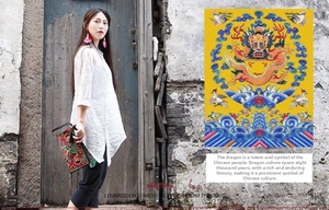 Close-up of vibrant dragon embroidery on ethnic style satin clutch with traditional patterns