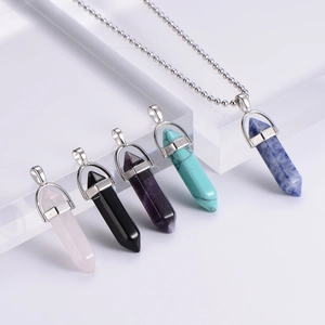 Close-up of hexagonal natural stone crystal bullet pendants in five distinct colors