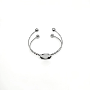 Detail of silver stainless steel double C-shaped bangle with blank round bezel setting