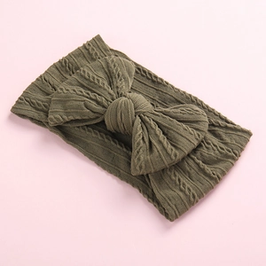 Close-up of olive green cable knit baby headband with a large decorative bow detail