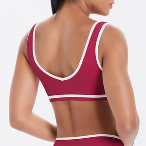 Gros plan d'un soutien-gorge de sport rouge foncé avec bordure blanche et dos ouvert